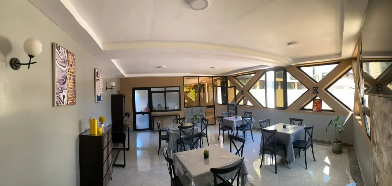 Salle du restaurant du Vitalo Lodge, tables dressées et grandes baies vitrées